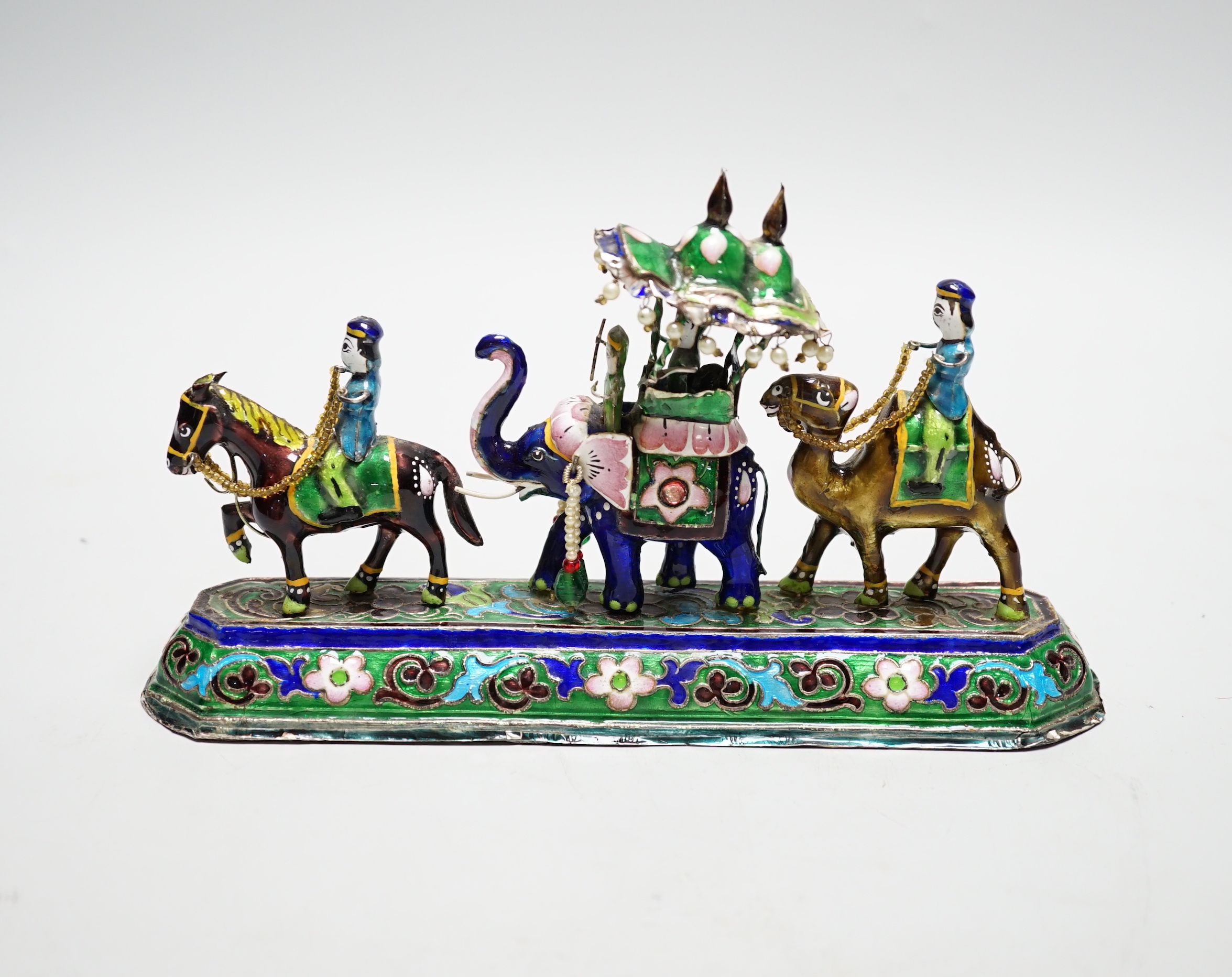 A 20th century Indian white metal and polychrome enamel figural group, with elephants and figures, stamped to base 'BHI SILVER', weighted, length 23cm.